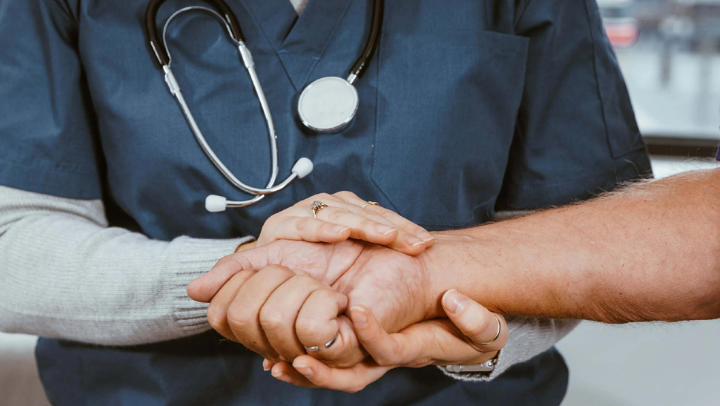 Photo of a doctor embracing a patient's hand