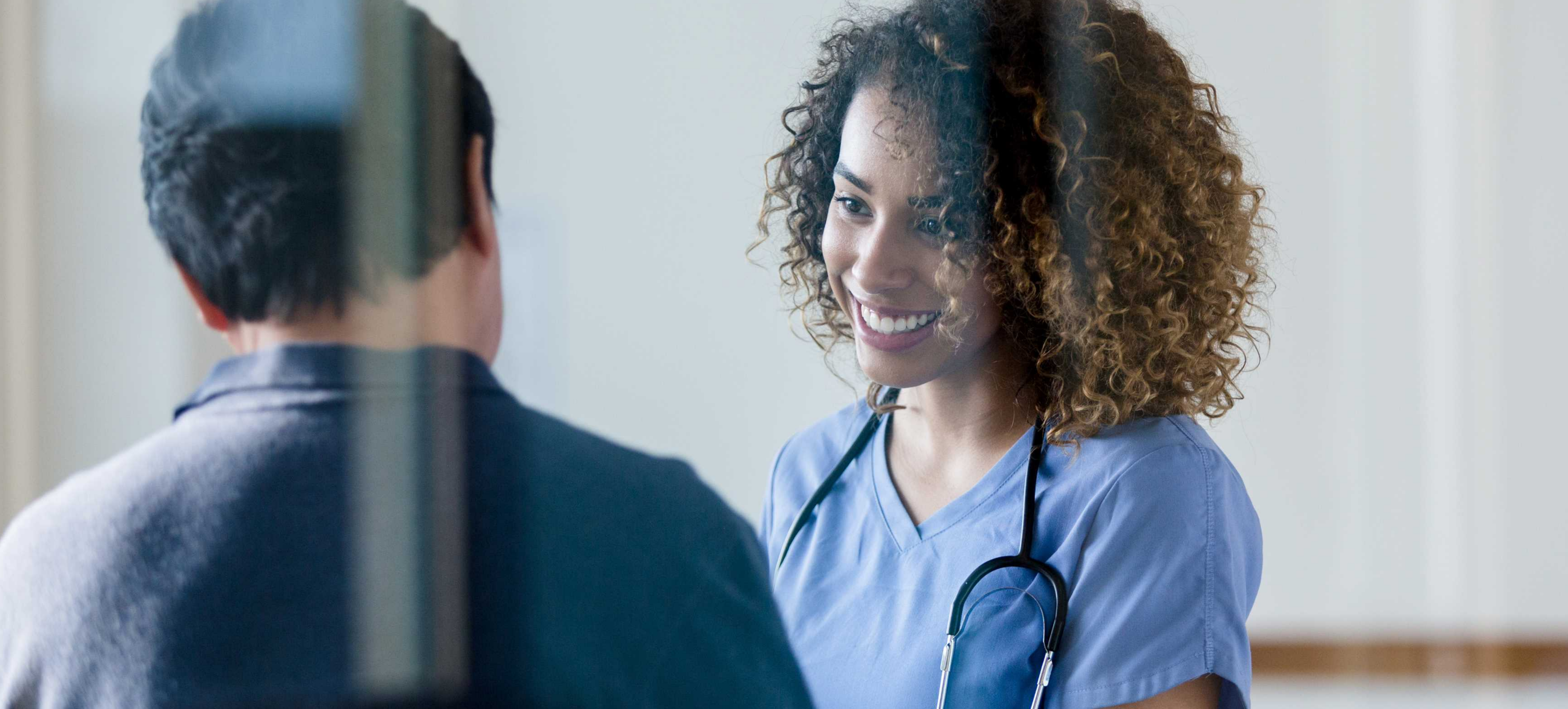 Woman doctor smiling at male patient or colleague
